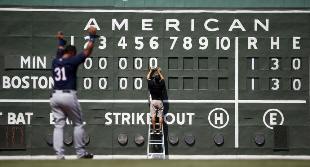 This scoreboard likely looks familiar to Boston Red Sox fans. Down at the team's spring training facility, Sox intern Tim Batesole changes the scoreboard during a game on March 18 in Fort Myers, Fla. (Brynn Anderson/AP)
