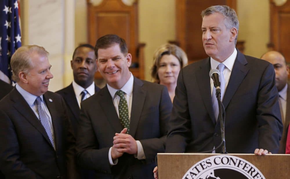 New York City Mayor Bill de Blasio addresses members of the media as Boston Mayor Marty Walsh, center, and Seattle Mayor Ed Murray, left, talk during a media availability after a U.S. Conference of Mayor's Cities of Opportunity Task Force session at historic Faneuil Hall Monday, March 23, 2015, in Boston. (AP)