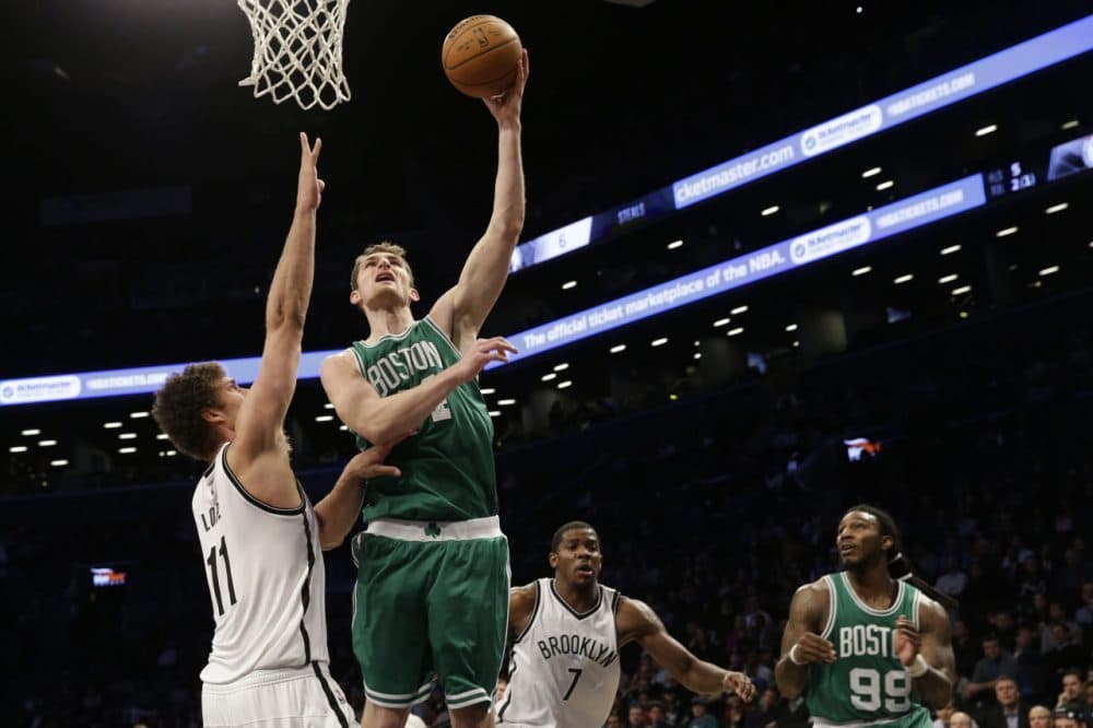 Celtics center Tyler Zeller (44) goes to the basket past Brooklyn Nets center Brook Lopez. (AP/Mary Altaffer)