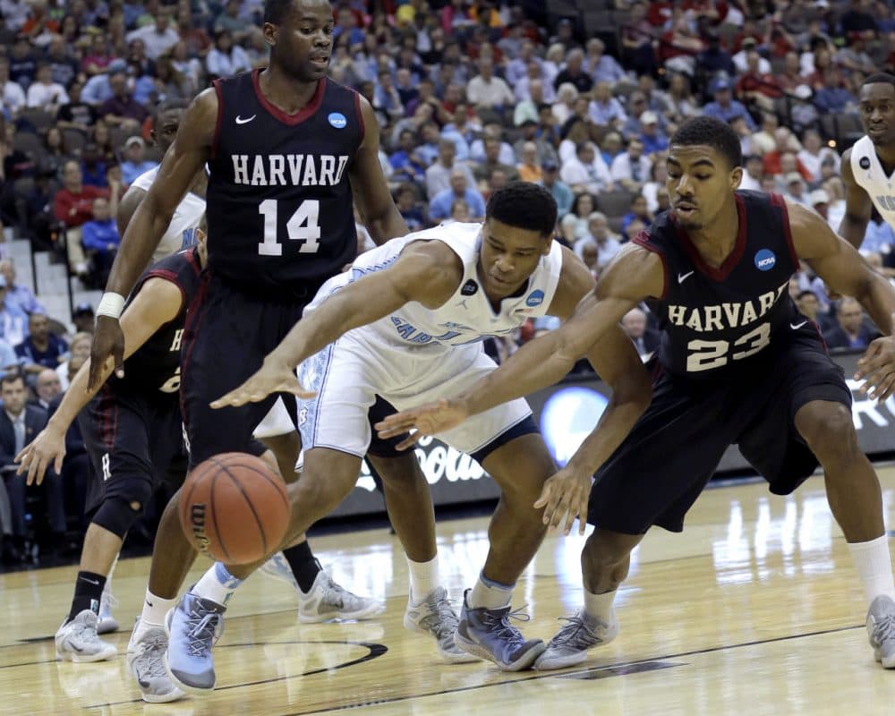 North Carolina forward Isaiah Hicks, center, and Harvard guard Wesley Saunders, right, reach for a loose ball in front of Harvard's Steve Moundou-Missi, left, during the second half of their game Thursday in Jacksonville, Fla. (John Raoux/AP)