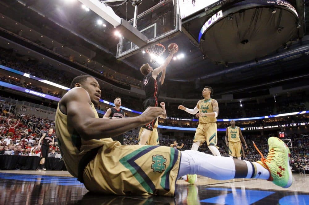 Notre Dame's Demetrius Jackson rolls on the floor after trying to stop Northeastern's Scott Eatherton. (Gene J. Puskar/AP)
