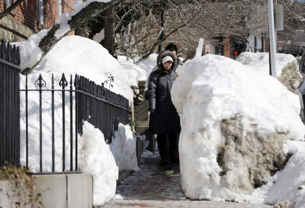 Pedestrians walk single file through snow banks on a Beacon Street sidewalk in Boston last month. (Elise Amendola/AP) 