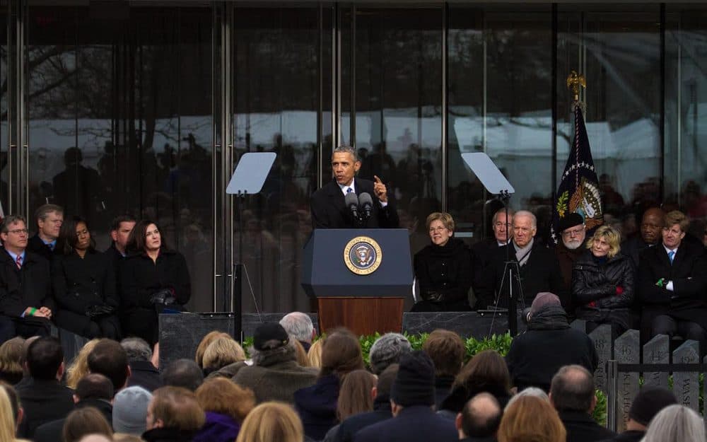 Surrounded by Kennedys and other politicians, President Obama speaks at the dedication of the Edward M. Kennedy Institute for the United States Senate in Boston on Monday. (Jesse Costa/WBUR)