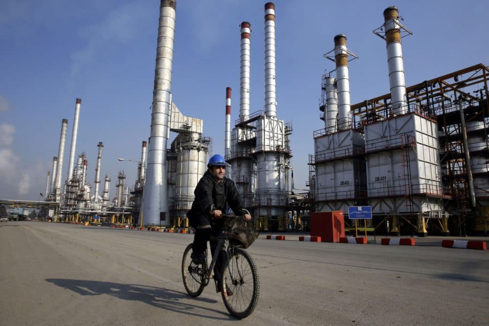 An Iranian oil worker rides his bicycle at the Tehran's oil refinery south of the capital Tehran, Iran, on Dec. 22, 2014. (Vahid Salemi/AP)