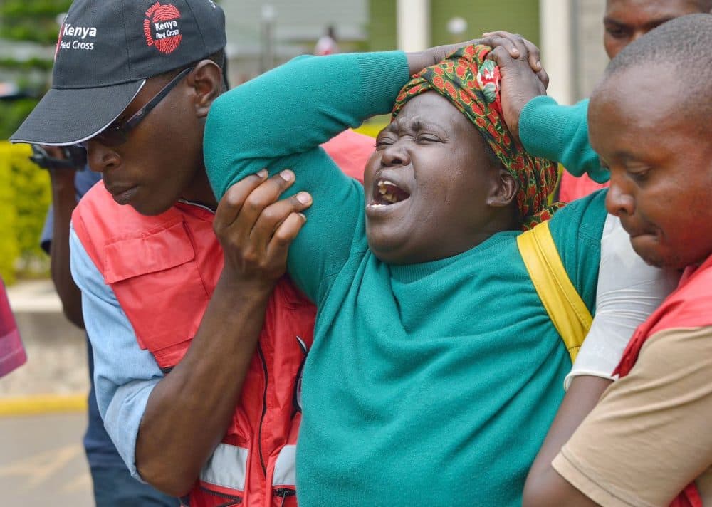 Members of the Red Cross help a woman after she viewed the body of a relative killed in the attack, at the Chiromo funeral parlor in the Kenyan capital, Nairobi, on April 3, 2015. (Tony Karumba/AFP/Getty Images)