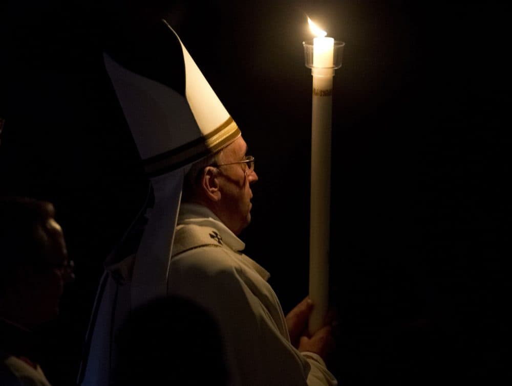 Pope Francis holds a white candle as he arrives for an Easter vigil service, in St. Peter's Basilica, at the Vatican, Saturday, April 4, 2015. (AP Photo/Andrew Medichini)