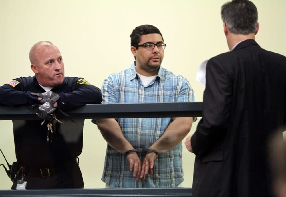 Carlos Colina, center, speaks with his attorney John Cunha, Jr., right, during his arraignment Monday. (Chitose Suzuki/The Boston Herald/ Pool)