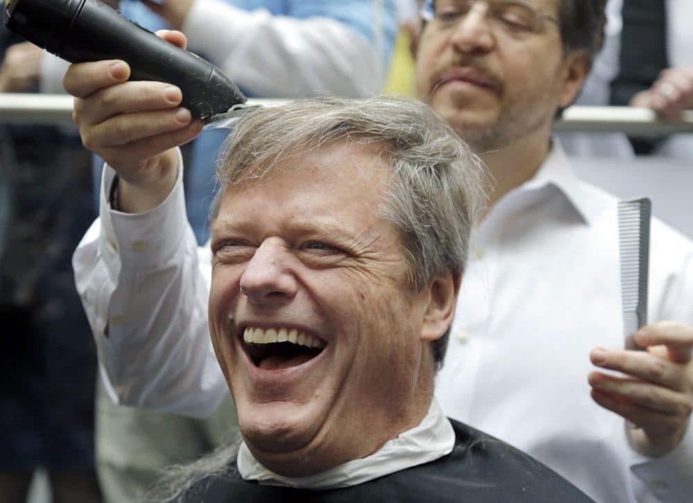 Gov. Charlie Baker reacts as he gets a buzz cut during a fundraising drive at Granite Telecommunications in Quincy, Mass. (Elise Amendola/AP)