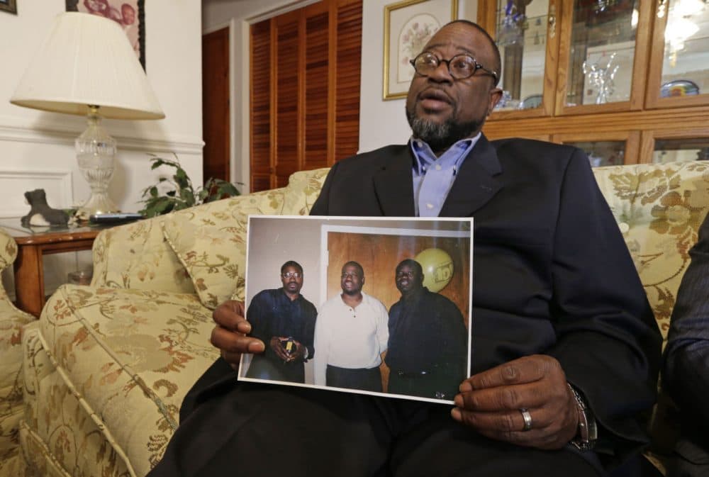 Anthony Scott holds a photo of himself, center, and his brothers Walter Scott, left, and Rodney Scott, right, as he talks about his brother at his home near North Charleston, S.C., Wednesday, April 8, 2015. Walter Scott was killed by a North Charleston police officer after a traffic stop on Saturday. The officer, Michael Thomas Slager, has been charged with murder. (Chuck Burton/AP)