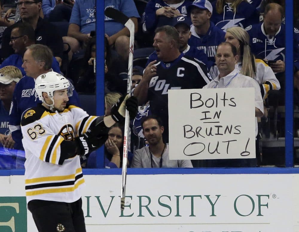 A Tampa Bay Lightning fan holds up a sign as Boston Bruins left wing Brad Marchand skates by.  Bruins were eliminated from the playoffs. (AP Photo/Chris O'Meara)