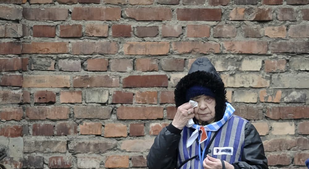 A reflection on why we study and remember the Holocaust. In this photo, a Holocaust survivor wipes her eye while standing outside a detention block of the Auschwitz Nazi death camp in Oswiecim, Poland, Tuesday, Jan. 27, 2015. (Alik Keplicz/AP)
