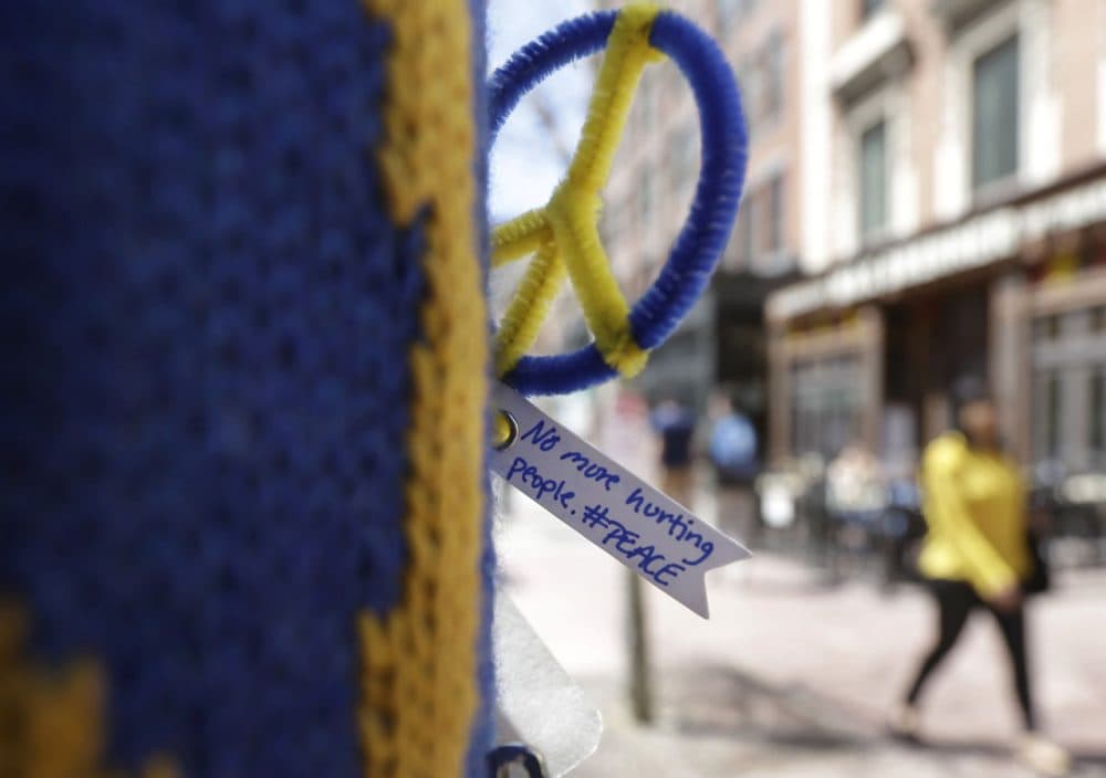 A peace symbol and a message are attached to a lamp post near one of two blast sites close to the finish line of the Boston Marathon, Wednesday, April 15, 2015. (Steven Senne/AP)