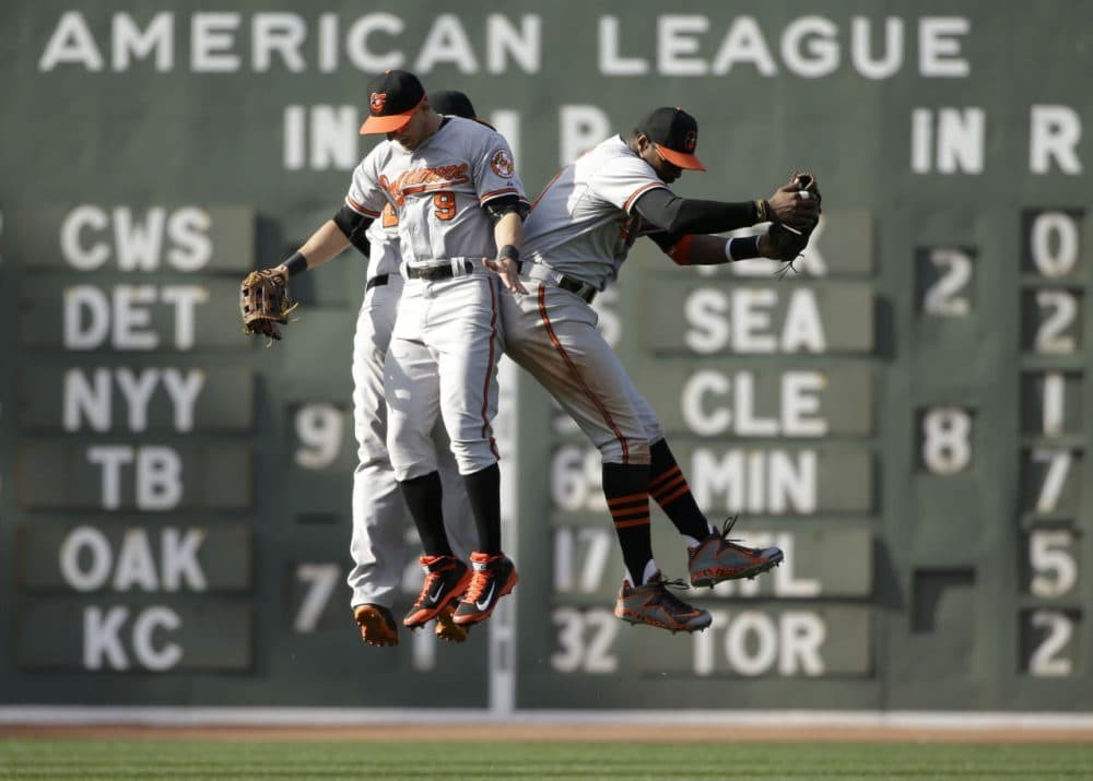 Baltimore Orioles Travis Snider, David Lough and Adam Jones jump in the air as they celebrate their 8-3 win over the Boston Red Sox on April 19, 2015, in Boston. (Steven Senne/AP)