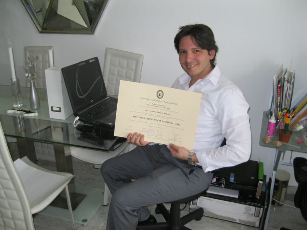 Guennady Rodriguez shows off his Cuban MBA degree at his Miami home. (Tim Padgett / WLRN.org)