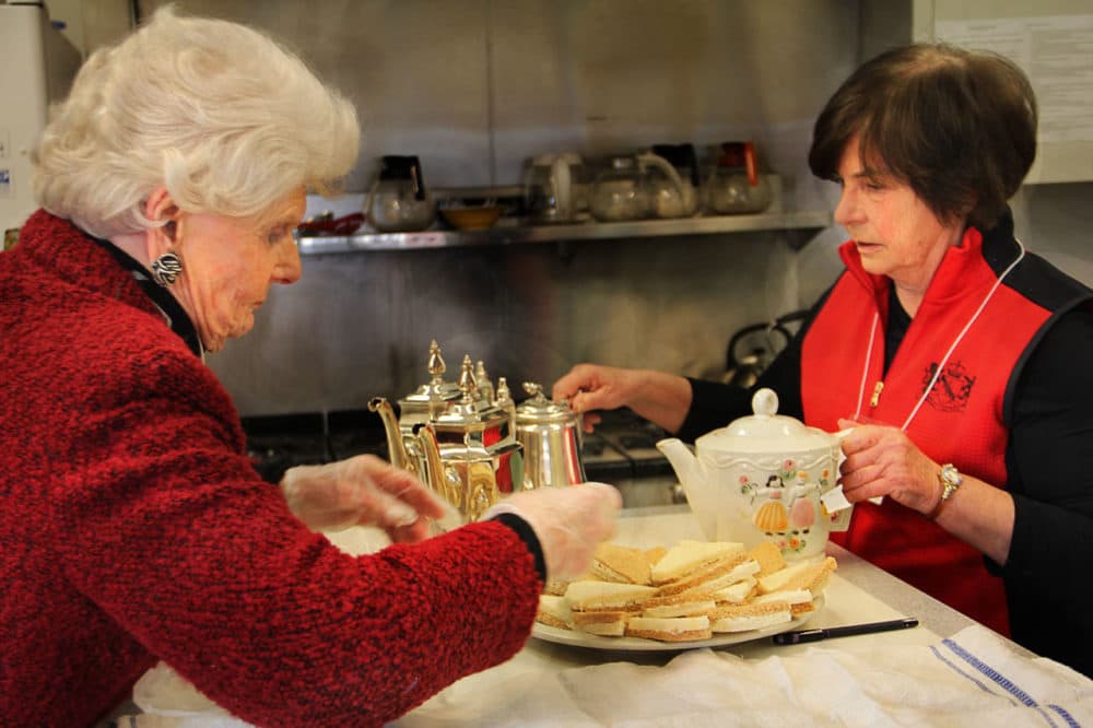 Tuesday Club members Alice Wilmont (left) and Karen Fulco (right) prepare tea and traditional tea sandwiches. (Shannon Dooling/WBUR)