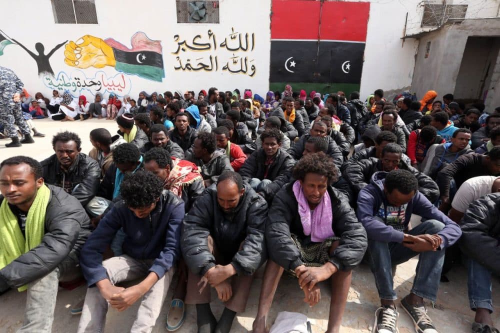 Migrants who were hoping to reach Europe by boat sit at Abu Salim detention centre for illegal migrants in the Libyan capital Tripoli on April 21, 2015, after they were detained at a Libyan port as they waited inside a boat to cross the Mediterranean Sea, according to Libyan security forces. (Mahmud Turkia/AFP/Getty Images)