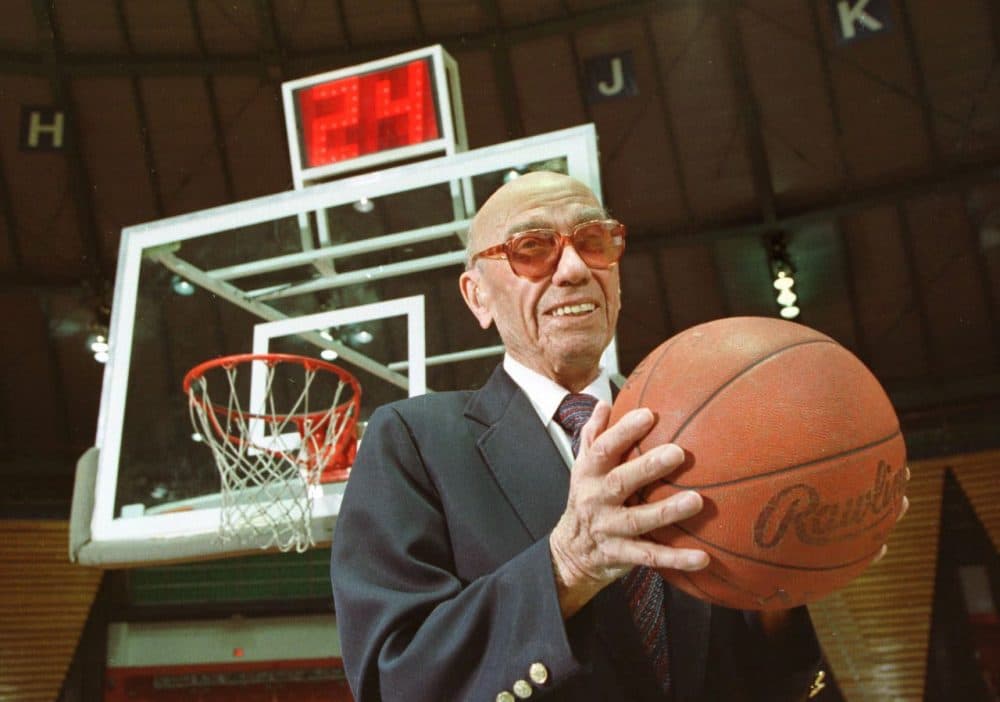The late Danny Biasone, an innovator of the 24-second shot clock for professional basketball, is shown in this March 8, 1992 photograph at a gym at Syracuse University in Syracuse, N.Y. Behind him is a modern shot clock. Biasone and other National Basketball Association owners met in Syracuse in 1954 and tested the 24-second clock at a basketball game in a local school. That decaying school now is reaching out to the NBA for a donation.  (Michael Okoniewski/AP)