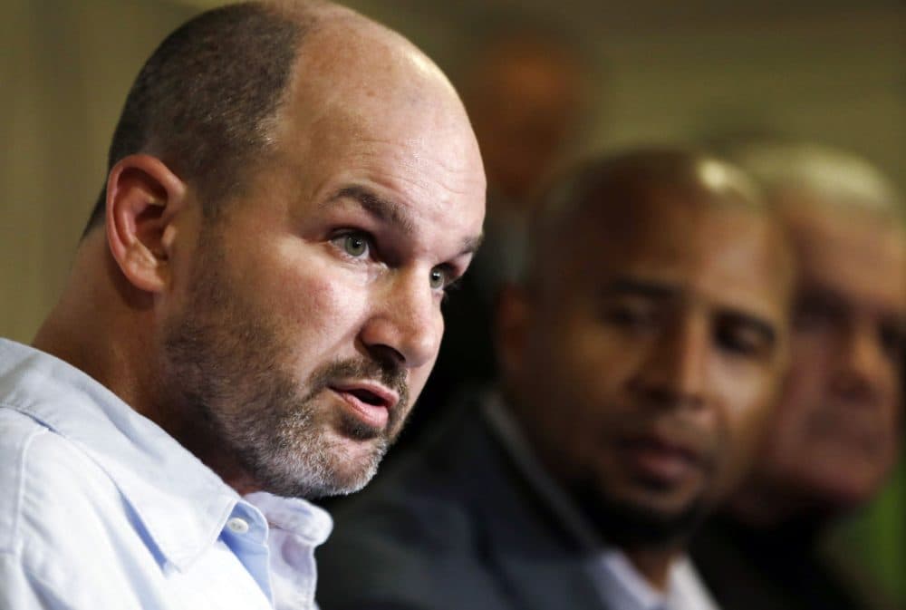 Former NFL player Kevin Turner speaks during a news conference in Philadelphia on April 9, 2013. As former players Dorsey Levens, center, and Bill Bergey listen. The NFL agreed Wednesday, June 25, 2014, to remove a $675 million cap on damages from thousands of concussion-related claims after a federal judge questioned whether there would be enough money to cover as many as 20,000 retired players. The plaintiffs include Kevin Turner, who played for the Philadelphia Eagles and New England Patriots and is now battling ALS. (Matt Rourke/AP)