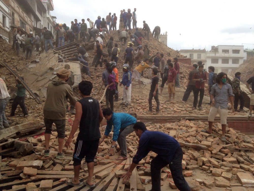 Volunteers help with rescue work at the site of a building that collapsed after an earthquake in Kathmandu, Nepal, Saturday, April 25, 2015. (AP Photo/ Niranjan Shrestha)