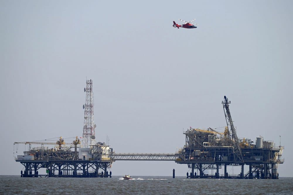 A U.S. Coast Guard helicopter flies over natural gas rigs in the waters of Mobile Bay off Dauphin Island, Ala., Sunday. Coast Guard crews are searching for five people missing in the water after a powerful storm capsized several sailboats participating in a regatta near Mobile Bay. (G.M. Andrews/AP)