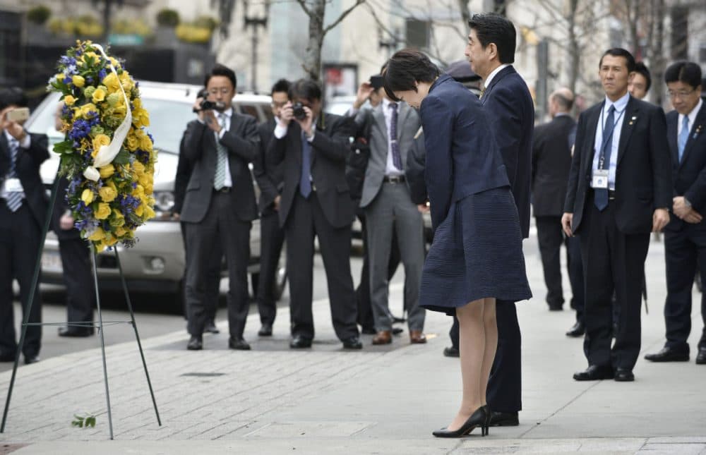 Japanese Prime Minister Shinzo Abe, center right, and his wife Akie bow after placing a wreath at the site of one of the 2013 Boston Marathon bomb blasts, on Monday. (Josh Reynolds/AP)