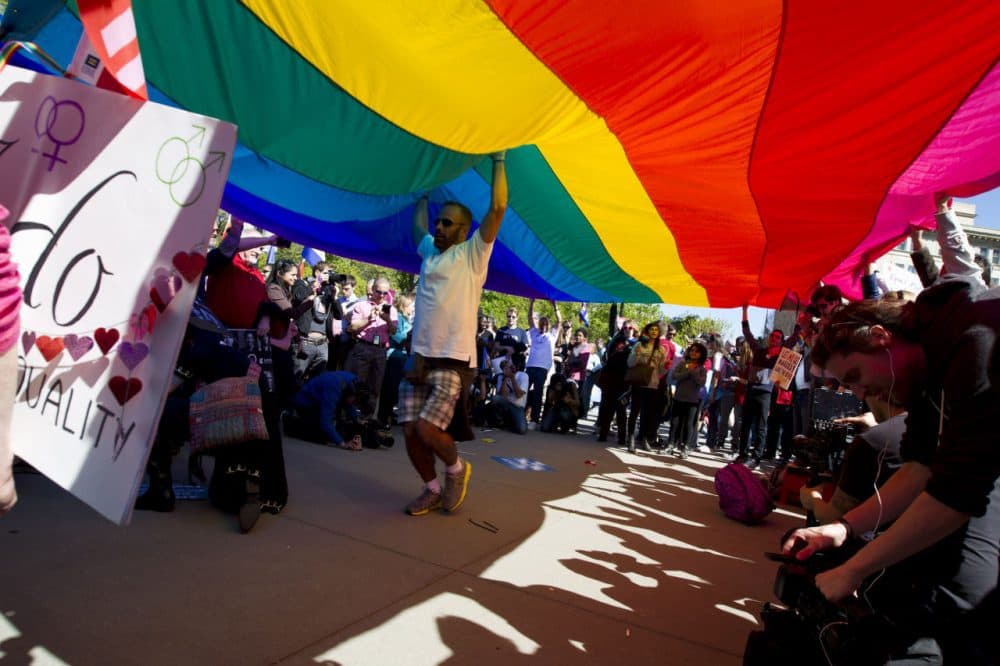 Demonstrators hold up a rainbow flag in front of the U.S. Supreme Court in Washington on Tuesday. (Jose Luis Magana/AP)