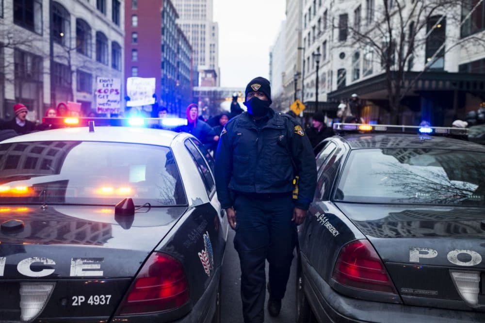 An unidentified Cleveland Police Officer walks between cars on Ontario Street December 21, 2014. Demonstrators  protesting the death of 12-year-old Tamir Rice locked arms to prevent police cruisers from passing. (Angelo Merendino/Getty Images)