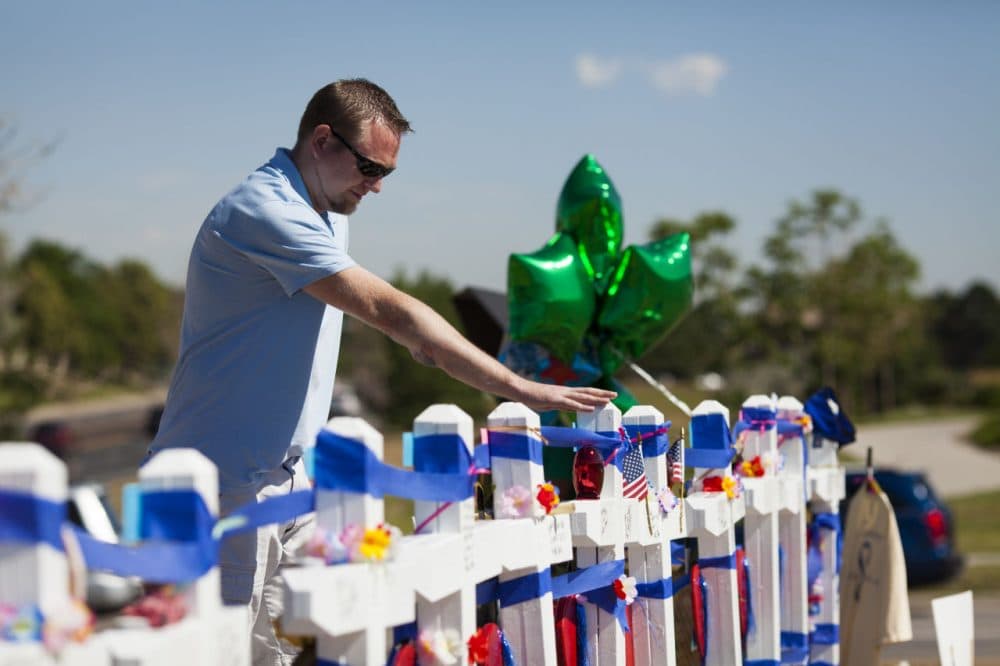 Joshua Nowlan, 32, visits the 12 crosses erected near the Aurora Municipal Building July 20, 2013 in Aurora, Colorado. A remembrance ceremony marks the one one-year anniversary of the Aurora Movie Theatre Shootings in which James Holmes killed 12 people and injured more than 50 during a mass shooting in 2012. (Dana Romanoff/Getty Images)