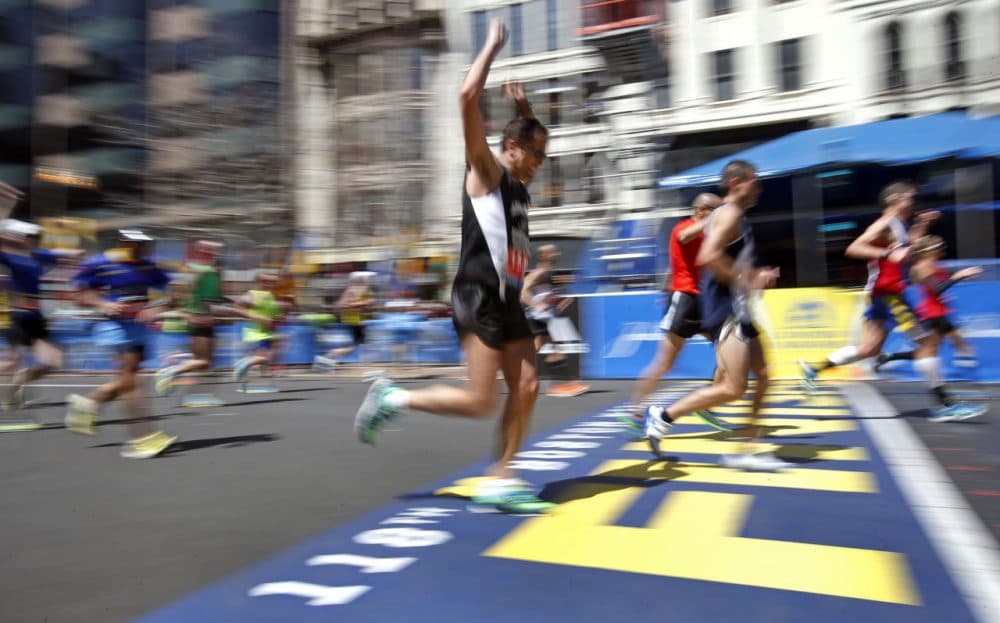Runners make their way over the finish line in the 118th Boston Marathon, Monday, April 21, 2014. (Elise Amendola/AP)