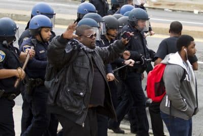 Baltimore police officers push back demonstrators who are throwing rocks at the police, after the funeral of Freddie Gray, on Monday, April 27, 2015, at New Shiloh Baptist Church in Baltimore.  (AP)