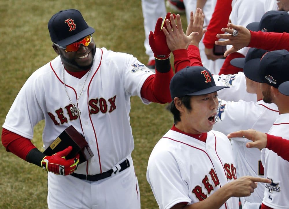 Boston Red Sox designated hitter David Ortiz, left, and relief pitcher Koji Uehara, lower right, celebrate with teammates after receiving their 2013 World Series rings at Fenway Park in Boston, Friday, April 4, 2014. (AP/Elise Amendola)