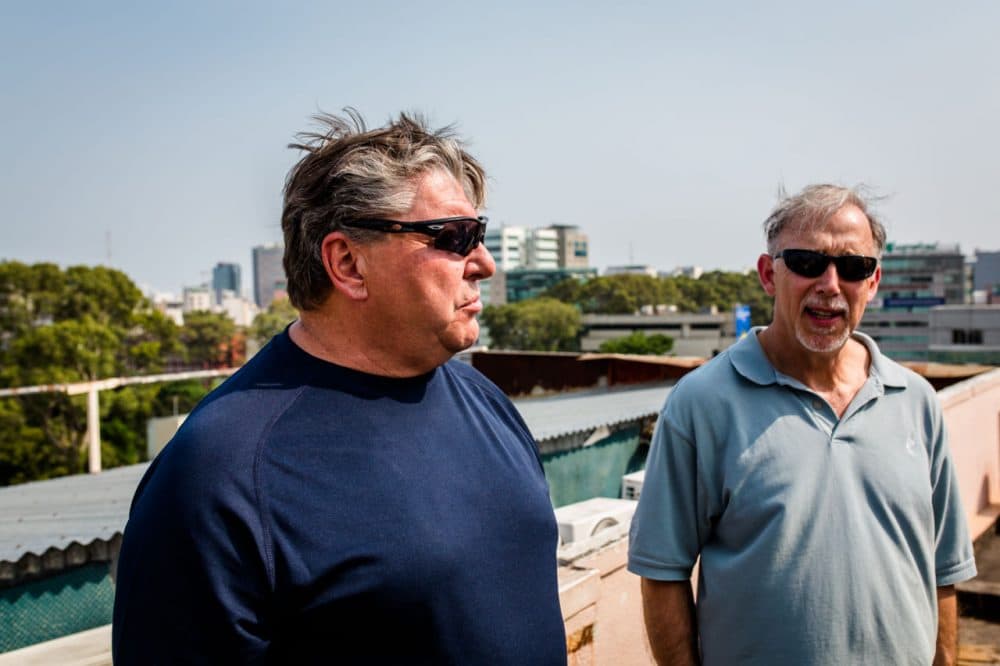 Former U.S. Marines John Ghilain, from Malden, left, and  Bill Newell, from Hopkinton, speak to WBUR atop the Saigon Star Monday in Ho Chi Minh City. In 1975, the building was their barracks.  This is their first trip back to Vietnam since they evacuated 40 years ago. (Quinn Ryan Mattingly for WBUR)