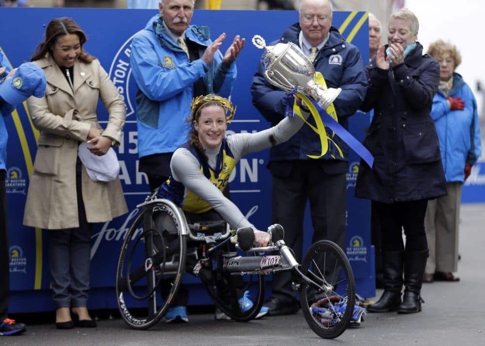 Tatyana McFadden  hoists her trophy after winning the women's wheelchair division. (Elise Amendola/AP)