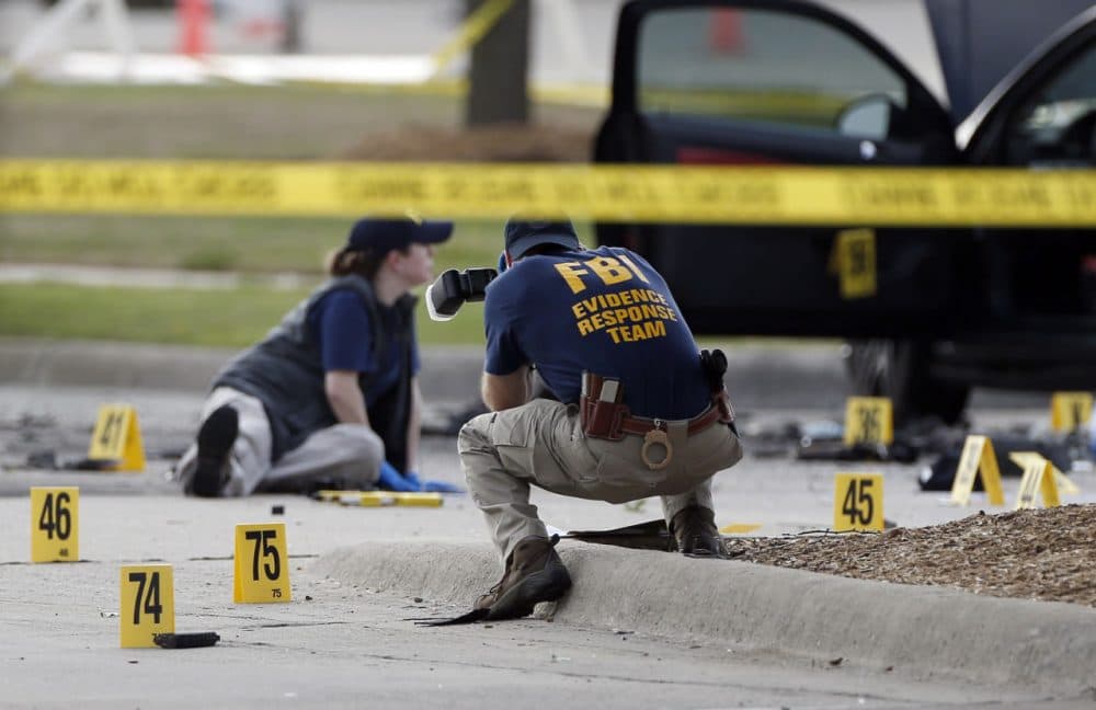 FBI crime scene investigators document the area around two deceased gunmen and their vehicle outside the Curtis Culwell Center in Garland, Texas, Monday, May 4, 2015. Police shot and killed the men after they opened fire on a security officer outside the suburban Dallas venue, which was hosting provocative contest for Prophet Muhammad cartoons Sunday night, authorities said. (Brandon Wade/AP)