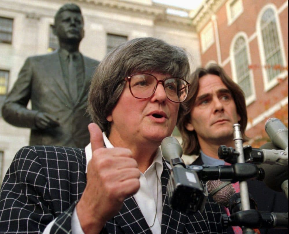 Death penalty opponent Sister Helen Prejean addresses members of the media as fellow opponent Paul Hill looks on while standing in front of a statue of President John F. Kennedy, behind, outside the Statehouse in Boston in 1997. (Kuni/AP)