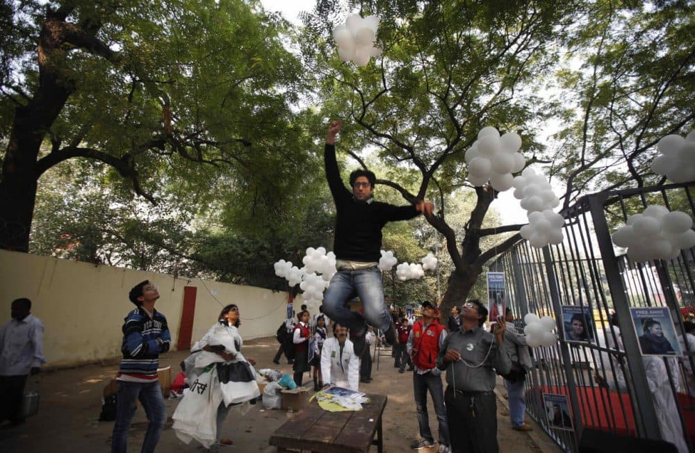 In this 2013 photo, a Greenpeace activist jumps to catch a thread tied to balloons during a protest in India. The nation is cracking down on foreign-funded charities lately. (Altaf Qadri/AP)