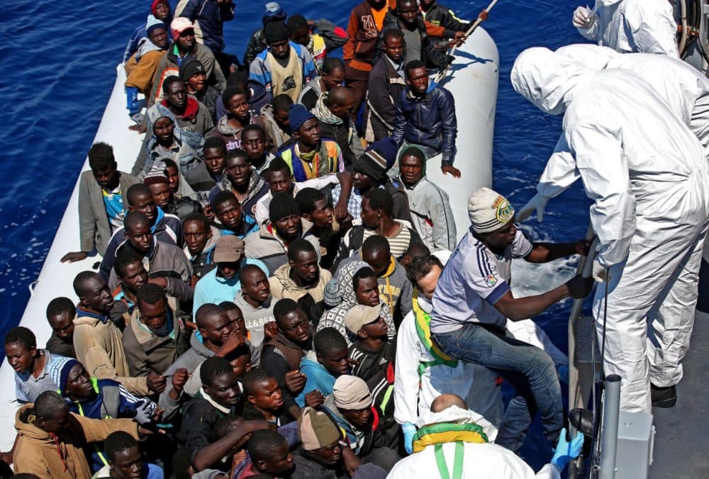 In this photo from April 22, 2015, migrants crowd and inflatable dinghy as rescue vassel &quot; Denaro &quot; of the Italian Coast Guard approaches them, off the Libyan coast, in the Mediterranean Sea. (Alessandro Di Meo/ANSA via AP)