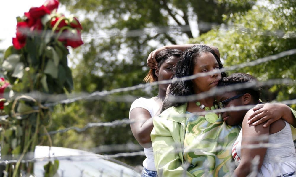 Area residents Alberta Harris, center, and Waynetta Theodore, left, and Christiena Preston, console each other as they pay their respects at a makeshift memorial, near the site where two Mississippi police officers were killed, Sunday, May 10, 2015, in Hattiesburg, Miss. (Rogelio V. Solis/AP)