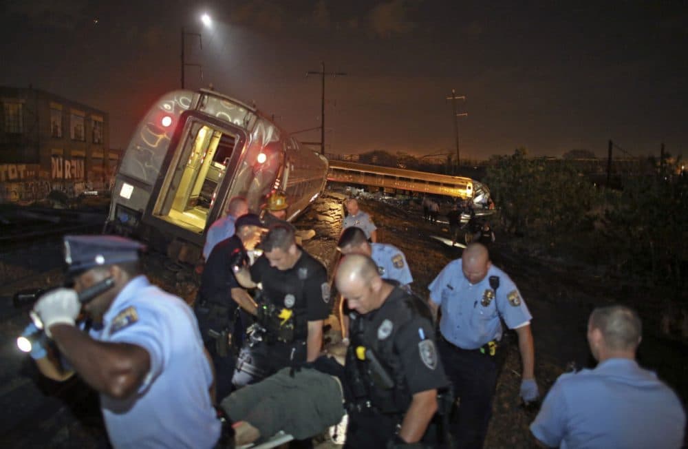 Emergency personnel work the scene of a train wreck, Tuesday, May 12, 2015, in Philadelphia. An Amtrak train headed to New York City derailed and crashed in Philadelphia. (Joseph Kaczmarek/AP)