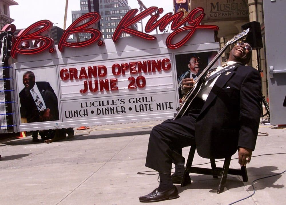 Blues legend B.B. King, holding his guitar &quot;Lucille,&quot; reacts as the neon sign for his New York restaurant and club arrives in Times Square, in May 2000. (Richard Drew/AP)
