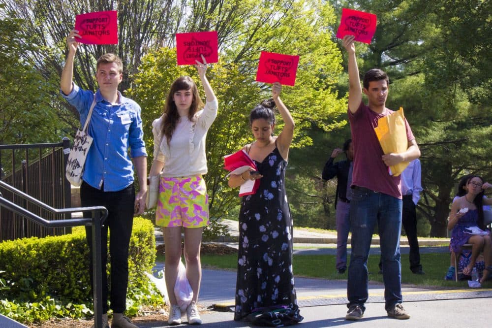Students hold signs in support of janitorial staff at Tufts University's commencement on May 17, 2015.(Peter Balonon-Rosen/WBUR)