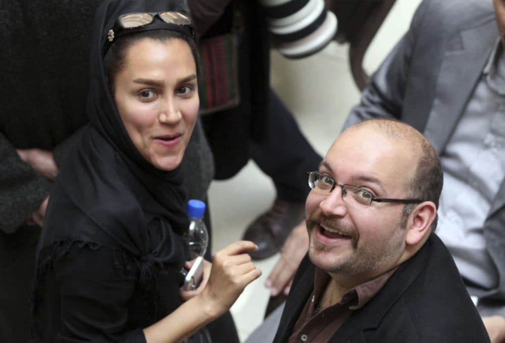 In this photo taken on April 11, 2013, Jason Rezaian, right, an Iranian-American correspondent for the Washington Post, and his wife Yeganeh Salehi, an Iranian correspondent for the Abu Dhabi-based daily newspaper The National, smile as they attend a presidential campaign of President Hassan Rouhani in Tehran, Iran. (Vahid Salemi/AP)