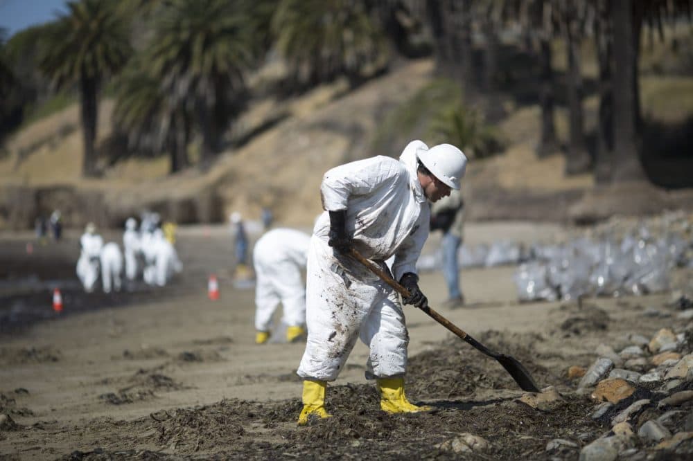 Crews clean oil from the beach at Refugio State Beach on May 20, 2015 north of Goleta, California. About 21,000 gallons spilled from an abandoned pipeline on the land near Refugio State Beach, spreading over about four miles of beach within hours. The largest oil spill ever in U.S. waters at the time occurred in the same section of the coast where numerous offshore oil platforms can be seen, giving birth to the modern American environmental movement. (David McNew/Getty Images)