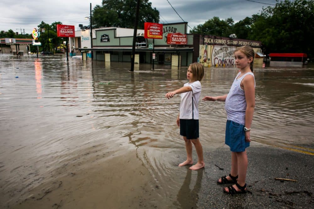 Murphy Canning and Annika Rolston watch as a street remains underwater from days of heavy rain on May 25, 2015 in Austin, Texas. Texas Gov. Greg Abbott toured the damage zone where one person is confirmed dead and at least 12 others missing in flooding along the Rio Blanco, which reports say rose as much as 40 feet in places, caused by more than 10 inches of rain over a four-day period. The governor earlier declared a state of emergency in 24 Texas counties. (Drew Anthony Smith/Getty Images)