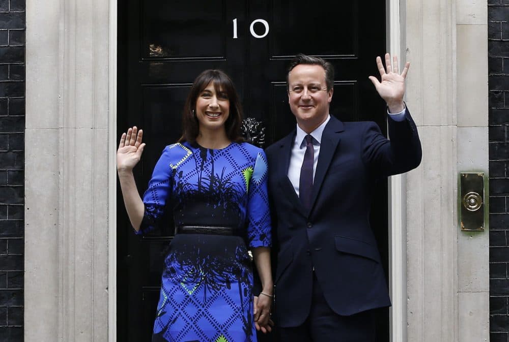Britain's Prime Minister David Cameron and his wife Samantha wave from the steps of 10 Downing Street in London Friday, May 8, 2015 after meeting Britain's Queen Elizabeth II where he informed her that he has enough support to form a government. The Conservative Party swept to power Friday in Britain's Parliamentary elections winning an unexpected majority. (Kirsty Wigglesworth/AP)