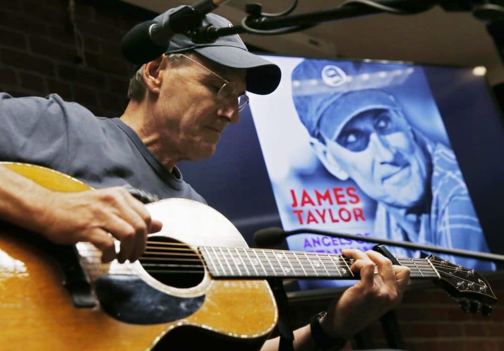 James Taylor plays guitar during a news conference to promote his new song &quot;Angels of Fenway&quot; before a baseball game between the Red Sox and the New York Yankees in Boston, Sunday, May 3, 2015. (AP/Michael Dwyer)