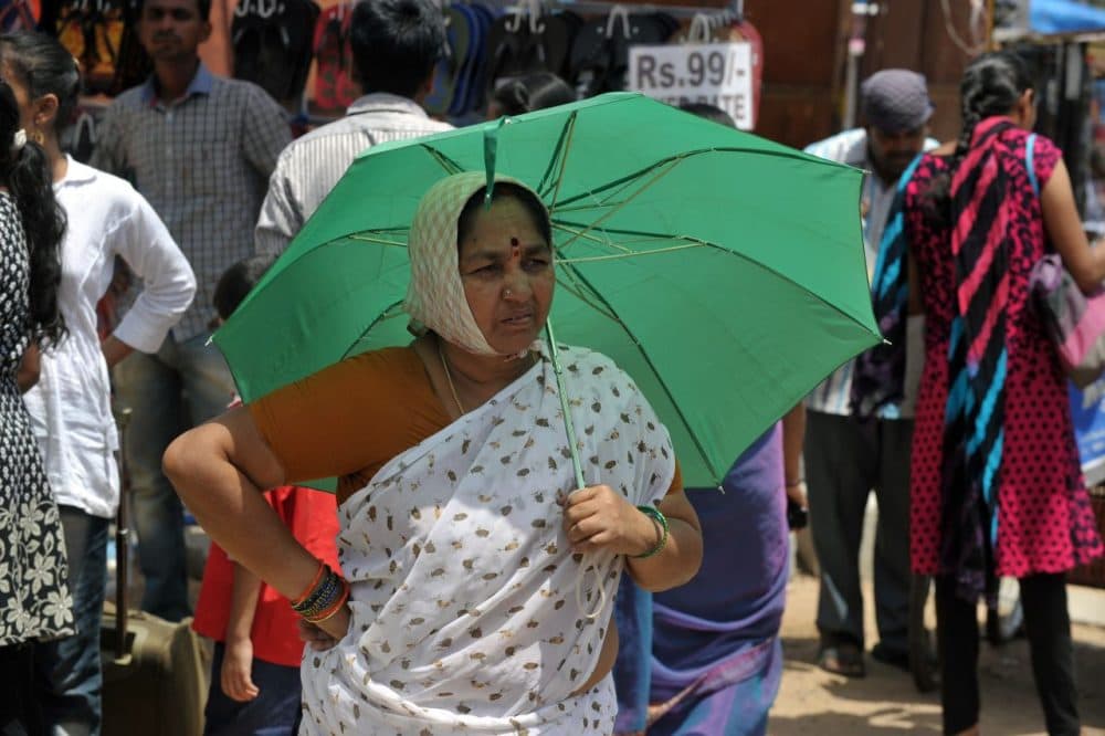 An Indian woman walks with an umbrella on a hot summer day in Hyderabad on May 26, 2015. (Noah Seelam/AFP/Getty Images)