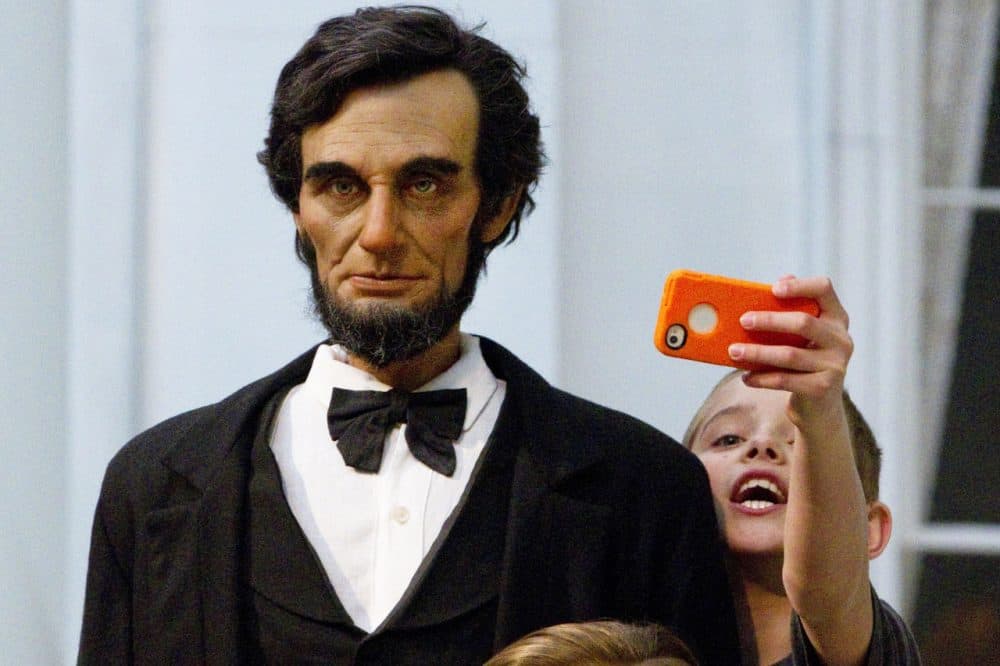 Zachary Hollis, 11, of Breadstown, Ill., stretches to capture a selfie with a life-size figure of Abraham Lincoln at the Abraham Lincoln Presidential Museum in Springfield, Ill. (Randy Squires/AP)