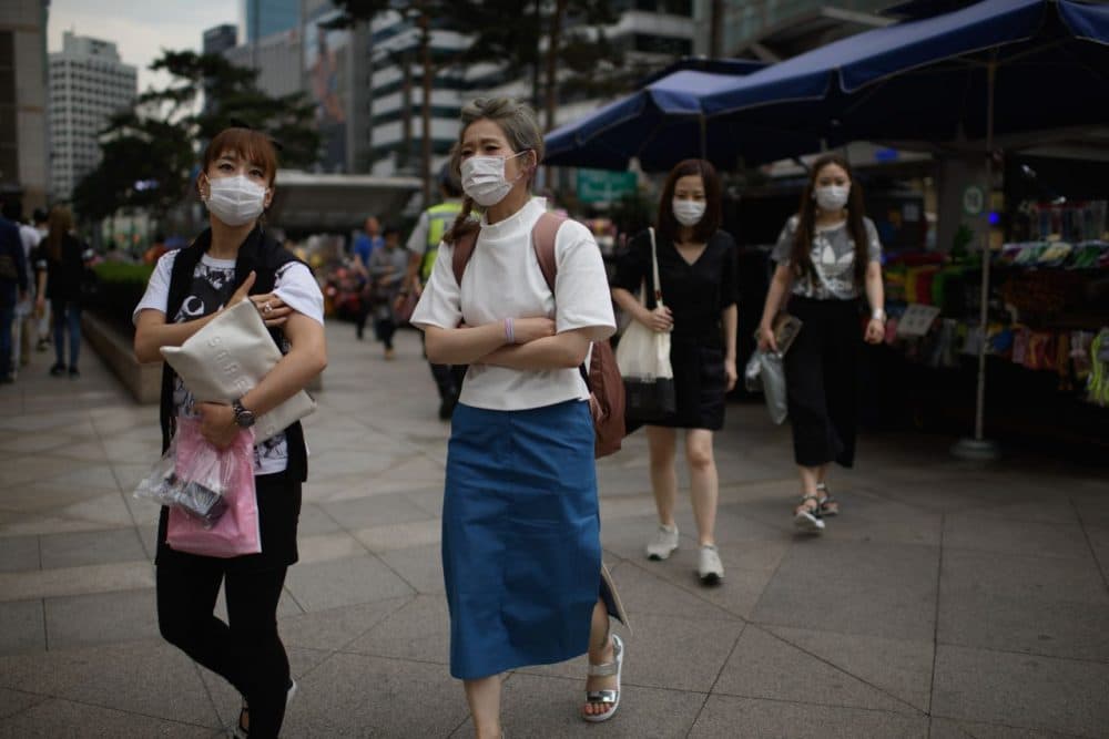 Women wearing face masks walk on a street in Seoul on June 5, 2015. South Korea reported a fourth death from Middle East Respiratory Syndrome (MERS), as an infected doctor fueled fears of a fresh surge in cases and prompted Seoul's mayor to declare 'war' on the virus. (Ed Jones/AFP/Getty Images)