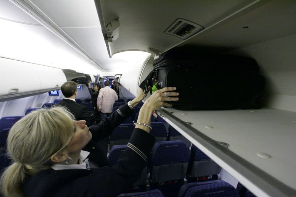 American Airlines flight attendant Renee Schexnaildre demonstrates the overhead baggage area during a media preview of the airline's new Boeing 737-800 jets, at Dallas Fort Worth International Airport in Grapevine, Texas. (Donna McWilliam/AP)